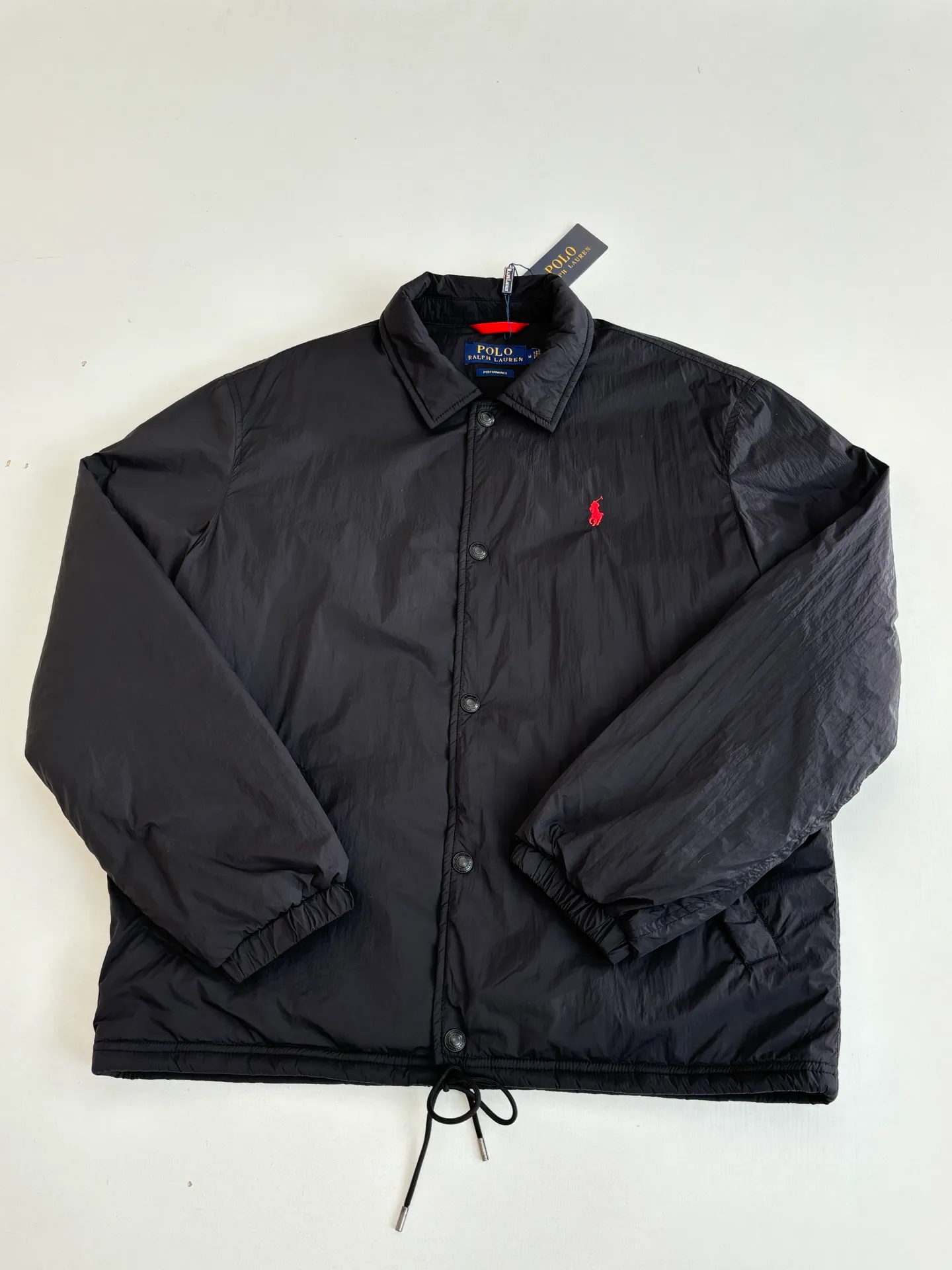 P670 Ralph Laure*/Ralph Lauren 25FW red label thin cotton coach jacket. The surface material is made of high-density nylon taffeta with a density of about 210T-300T. The surface is smooth and slightly matte. It has excellent windproof and waterproof performance (with DWR water-repellent treatment). It has strong wrinkle resistance and is easy to care for. It is in line with the positioning of American casual "durable and practical". Lining: Lightweight cotton-polyester blend lining (65% Polyester + 35% Cotton) Embroidery positioning: Precisely position through the template (12cm from the bottom of the neckline, 8cm from the placket) to ensure left and right symmetry and centering.  Size：S/M/L/XL